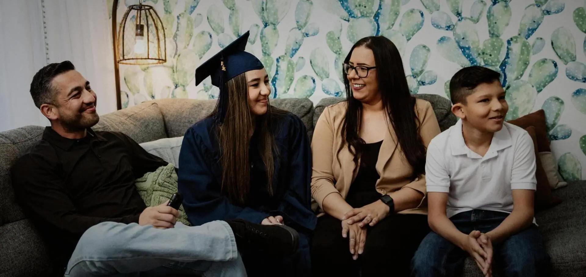 Family smiling next to a graduated student